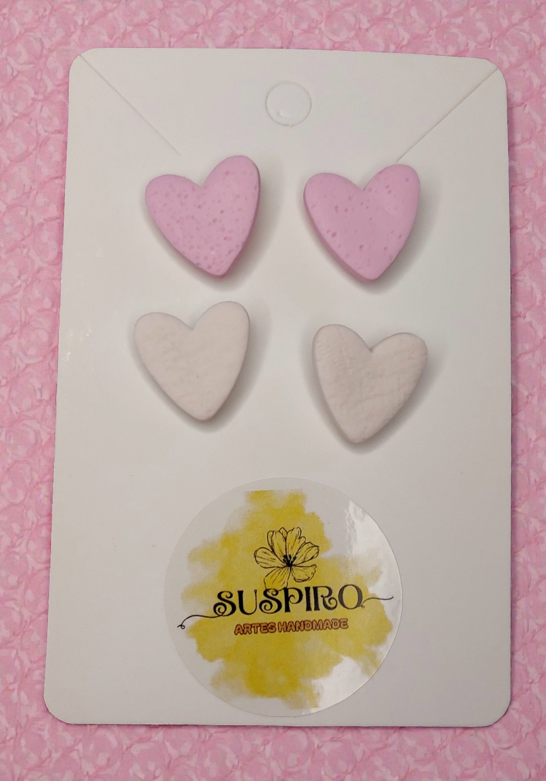 Brincos de coração em exposição com selo Suspiro